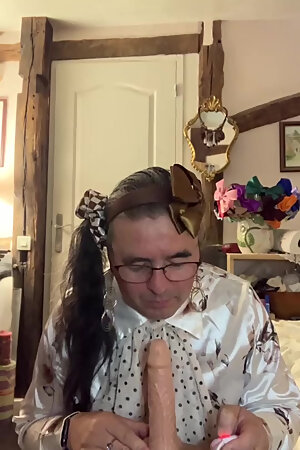 In an outfit with a little brown skirt to suck a dildo