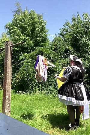 In a black and white maid outfit to hang out the laundry.