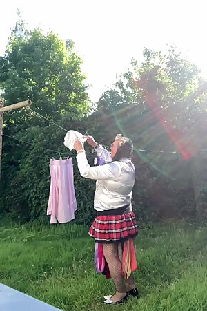 In schoolgirl outfit to hang the laundry