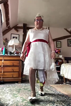 In an outfit with a long white lace dress styled like a wedding dress for an evening.