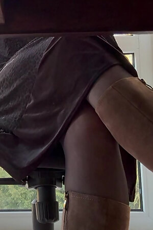 The secretary pampers herself with the vibrator under the desk